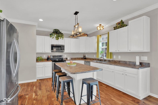 kitchen featuring appliances with stainless steel finishes, white cabinets, and sink