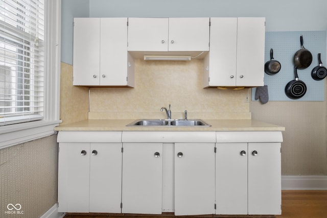 kitchen with a healthy amount of sunlight, white cabinets, and sink