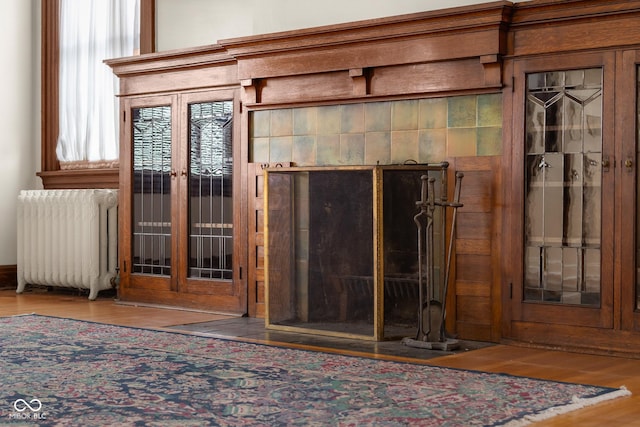 interior details with hardwood / wood-style flooring and radiator heating unit