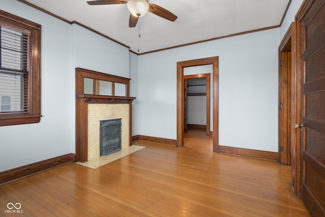 unfurnished living room with ceiling fan, crown molding, and light wood-type flooring