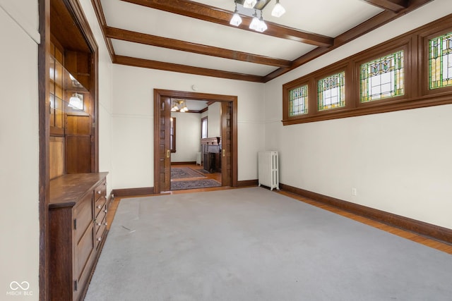 unfurnished room featuring beam ceiling and radiator heating unit