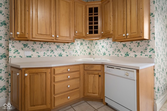 kitchen featuring light tile patterned floors, dishwasher, and sink