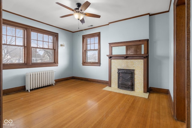 unfurnished living room with ceiling fan, radiator heating unit, ornamental molding, and light hardwood / wood-style floors