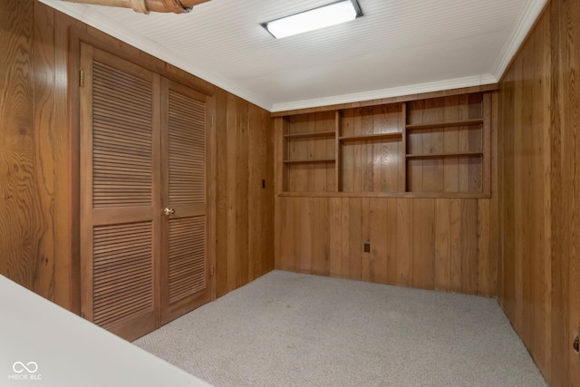 bedroom featuring light carpet, a closet, wooden walls, and ornamental molding