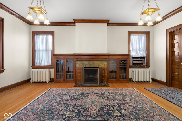 unfurnished living room with light hardwood / wood-style floors, a wealth of natural light, and radiator