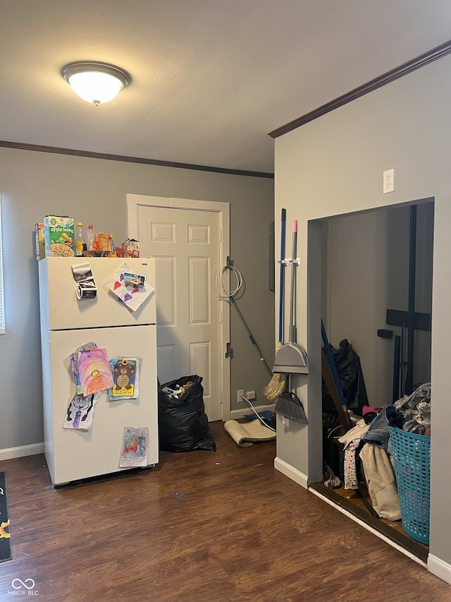 interior space featuring dark hardwood / wood-style flooring, ornamental molding, and white fridge