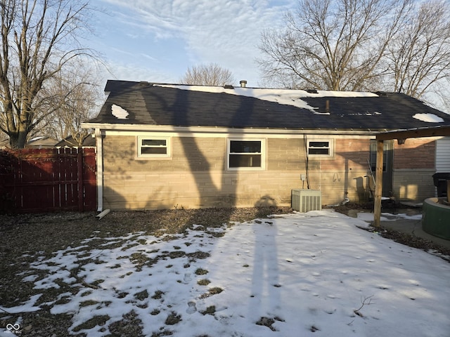 snow covered back of property with cooling unit