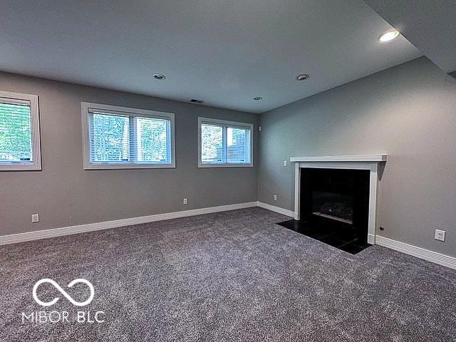 13650 Golden Ridge Ln, Fishers, IN 46055 - unfurnished living room featuring carpet floors, a fireplace with flush hearth, and recessed lighting