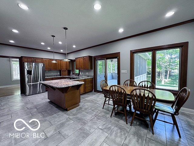 13650 Golden Ridge Ln, Fishers, IN 46055 - kitchen featuring stainless steel fridge, a kitchen island, recessed lighting, healthy amount of natural light, and ornamental molding