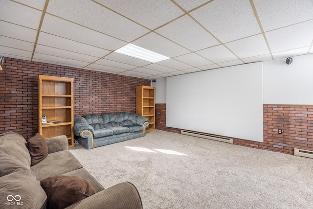 interior space with a baseboard radiator, a drop ceiling, carpet flooring, and brick wall