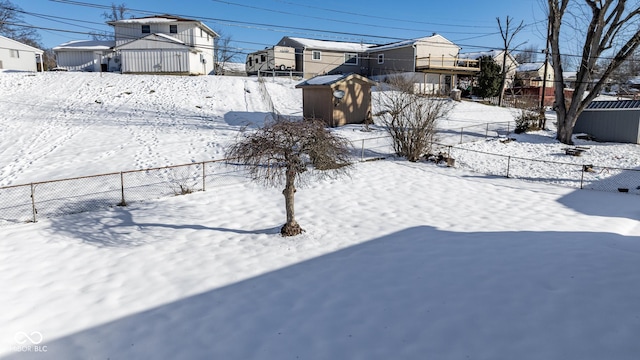 snowy yard with a storage shed