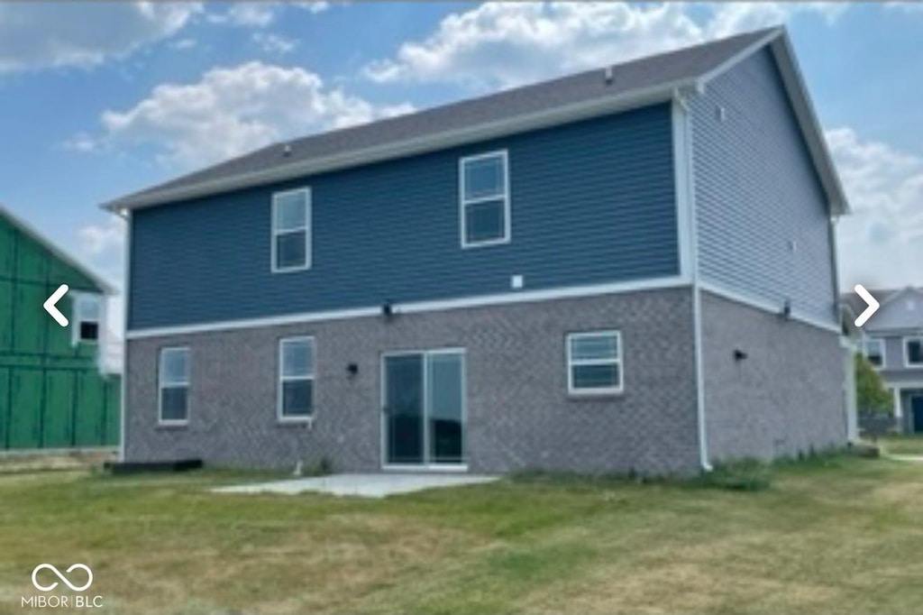 rear view of house featuring a lawn