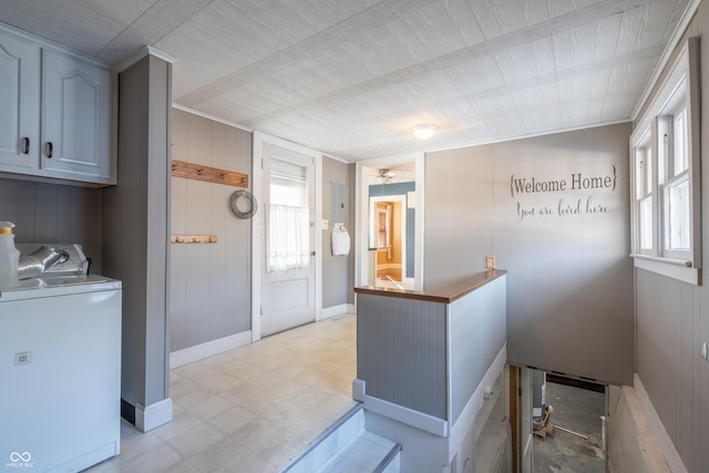 clothes washing area featuring cabinets, a wealth of natural light, and washer and clothes dryer