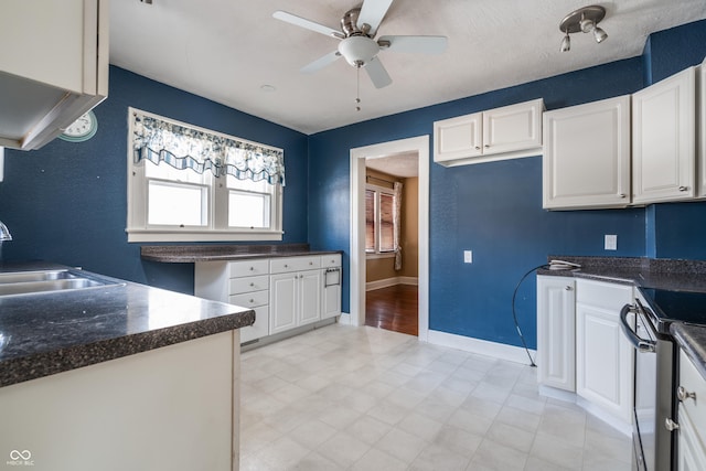 kitchen with ceiling fan, white cabinets, stainless steel electric range oven, and sink