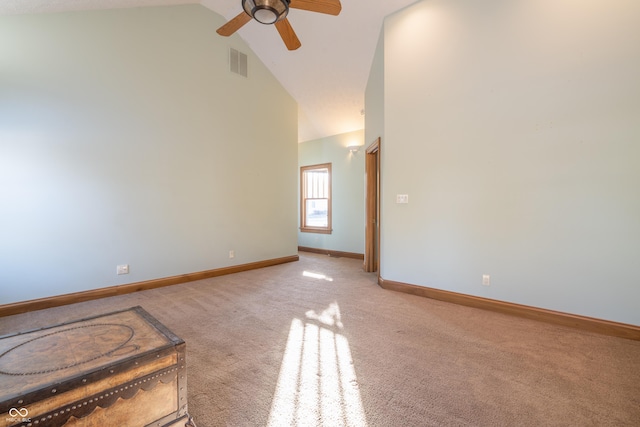 carpeted spare room with ceiling fan and high vaulted ceiling