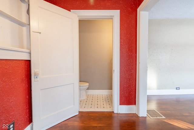 bathroom featuring hardwood / wood-style flooring and toilet