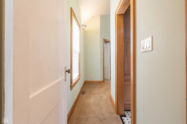 hall with light colored carpet and lofted ceiling