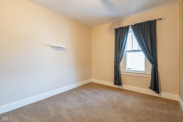 empty room with light carpet and a textured ceiling