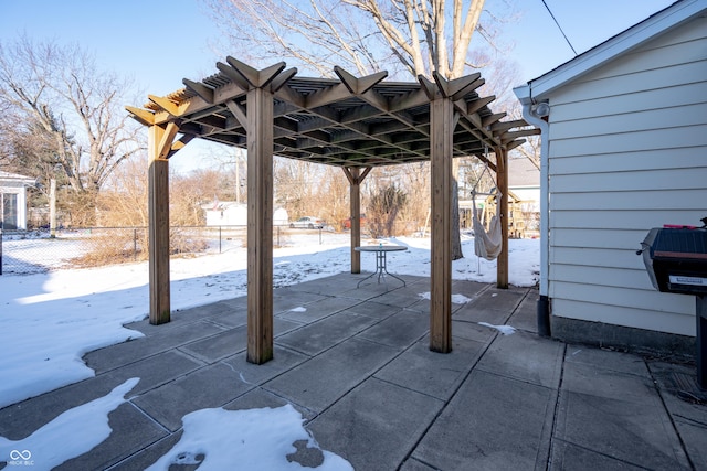 snow covered patio with a pergola