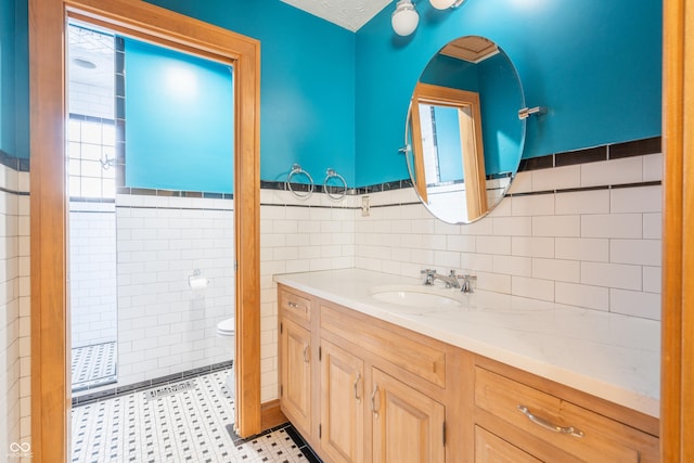 bathroom featuring toilet, tile walls, and vanity