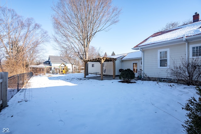 yard covered in snow featuring a pergola