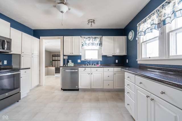 kitchen featuring a wealth of natural light, appliances with stainless steel finishes, white cabinets, and sink