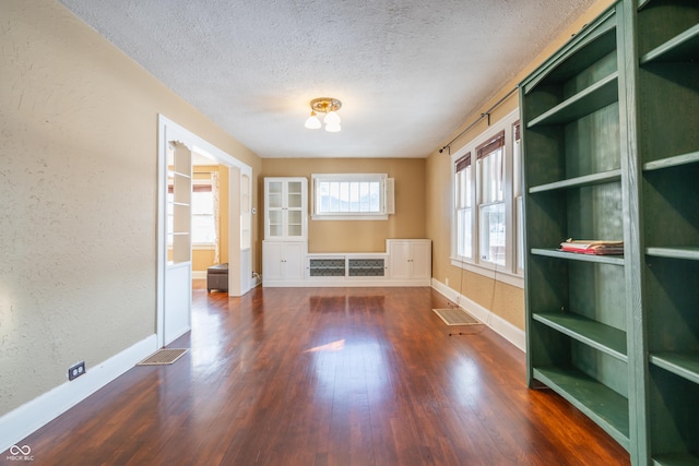 spare room with dark wood-type flooring and a textured ceiling