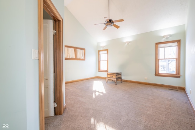 carpeted spare room with ceiling fan and high vaulted ceiling