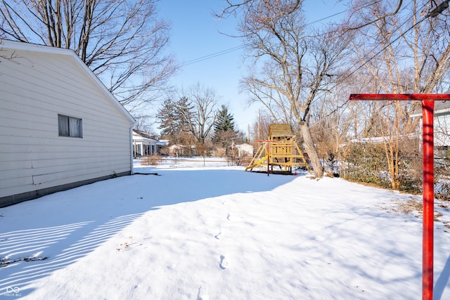 yard covered in snow with a playground