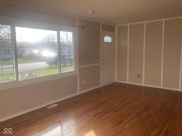 spare room with crown molding and wood-type flooring