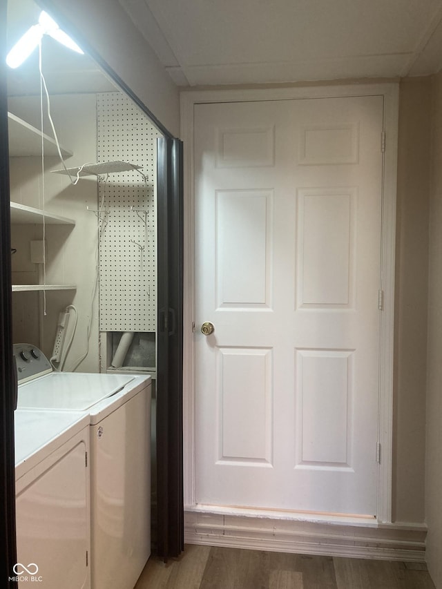 laundry room with separate washer and dryer and wood-type flooring