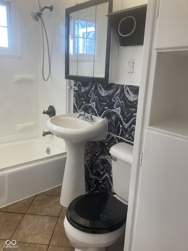 bathroom featuring tile patterned floors, toilet, and shower / washtub combination