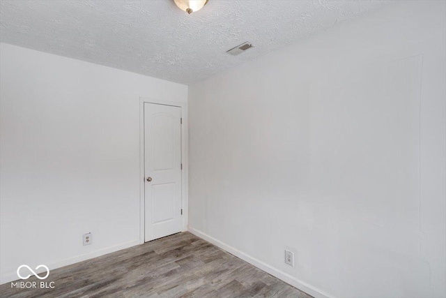 unfurnished room featuring a textured ceiling and hardwood / wood-style flooring