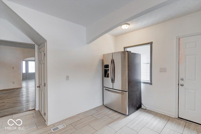 kitchen with stainless steel refrigerator with ice dispenser, french doors, and a textured ceiling