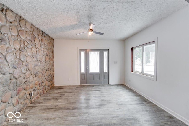 entryway with ceiling fan, a textured ceiling, and light hardwood / wood-style flooring