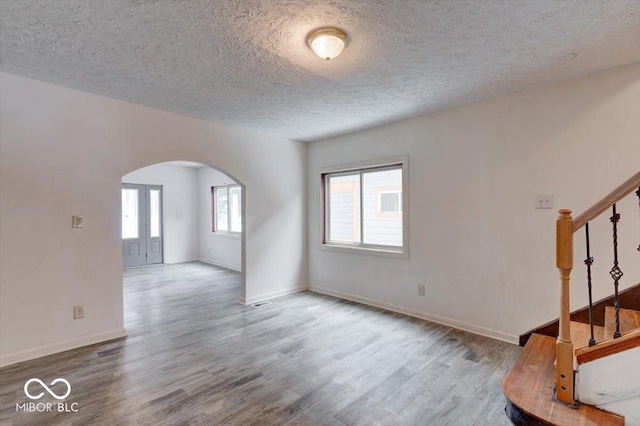 interior space with a textured ceiling and hardwood / wood-style floors