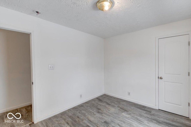 unfurnished room with light hardwood / wood-style floors and a textured ceiling