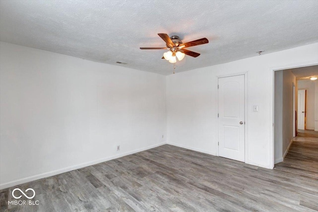 empty room featuring ceiling fan, a textured ceiling, and hardwood / wood-style flooring