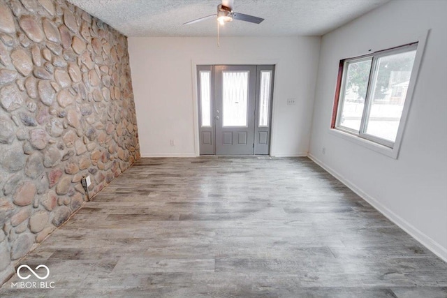 foyer with a textured ceiling, ceiling fan, and a healthy amount of sunlight