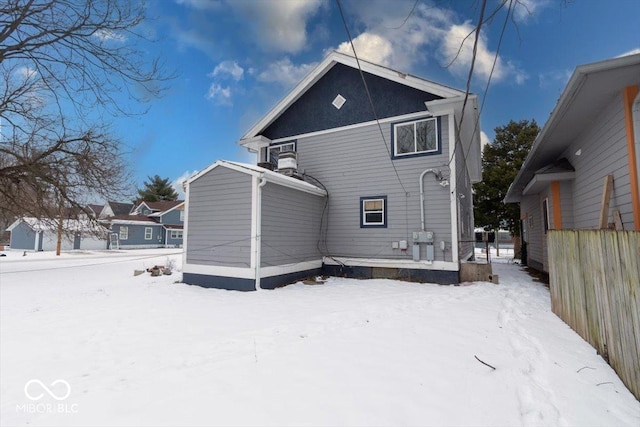 view of snow covered rear of property