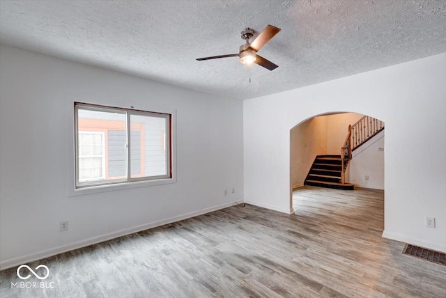 spare room featuring ceiling fan, a textured ceiling, and light hardwood / wood-style floors