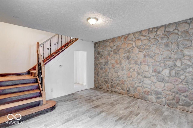 interior space featuring wood-type flooring and a textured ceiling