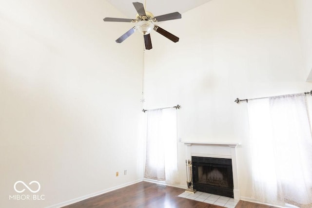 unfurnished living room with wood-type flooring, ceiling fan, and vaulted ceiling