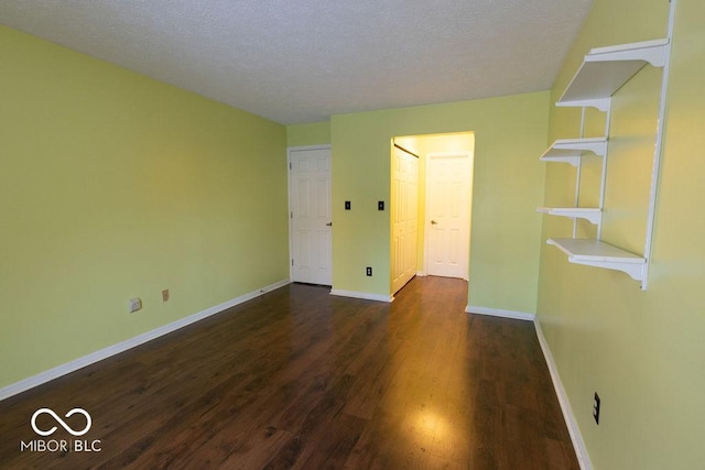 unfurnished room featuring dark hardwood / wood-style floors and a textured ceiling