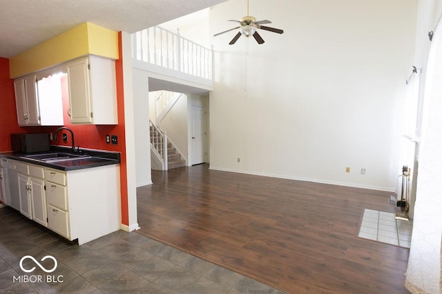 kitchen featuring sink, white cabinetry, a textured ceiling, dark tile patterned flooring, and ceiling fan