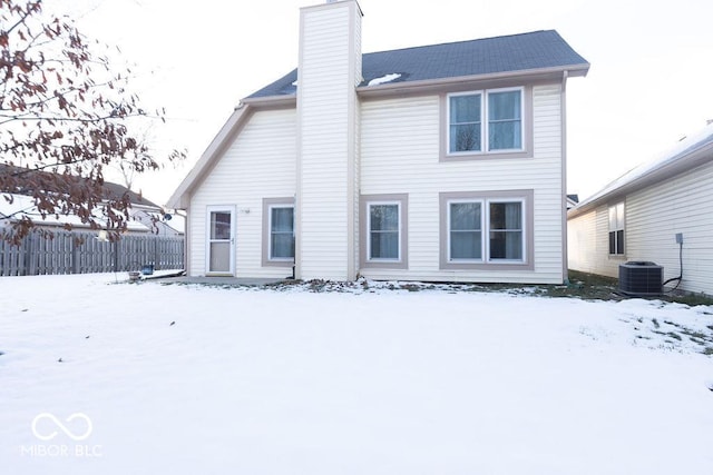 snow covered house with central air condition unit