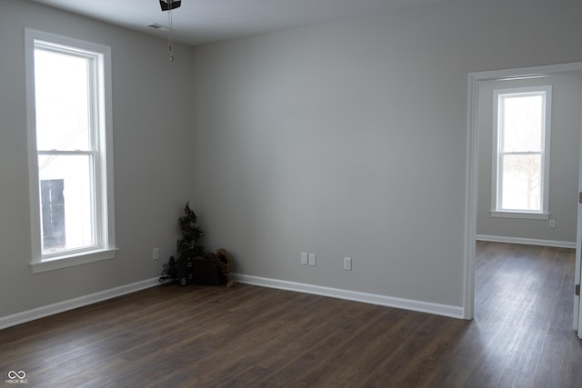 spare room with ceiling fan and dark wood-type flooring