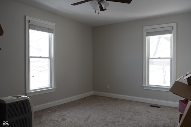 carpeted spare room featuring ceiling fan