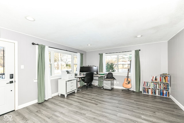 home office with a wealth of natural light and light hardwood / wood-style flooring