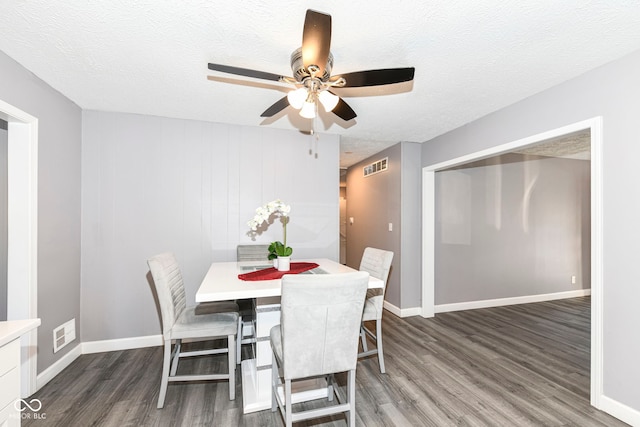 dining room featuring ceiling fan, dark hardwood / wood-style flooring, and a textured ceiling